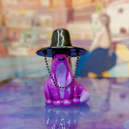Purple fox figurine wearing a traditional korean gat on a reflective surface with a colorful abstract background